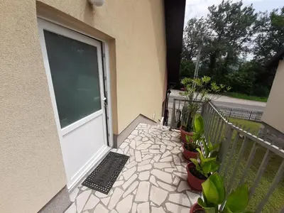 a balcony with a door with potted plants and a laptop at Restoran i sobe 