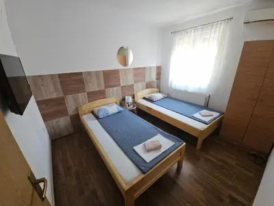 two beds in a small room with a window at Restoran i sobe 