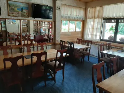 a dining room with tables and chairs and a flat screen tv at Restoran i sobe 