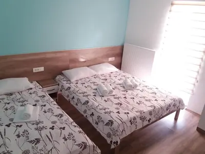a small bedroom with two beds and a window at Mediteran B&B in Prozor