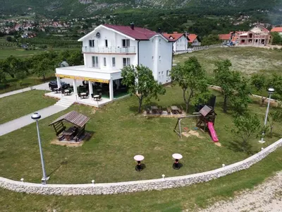 an aerial view of a white house with a playground at Mediteran B&B in Prozor