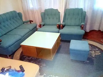 a living room with blue chairs and a coffee table at Apartman Retro Una in Banja Luka