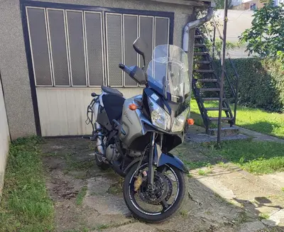a blue motorcycle parked in front of a garage at Apartman Retro Una in Banja Luka
