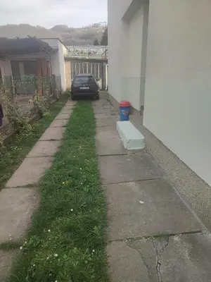 a sidewalk with a car parked next to a building at Apartman Retro Una in Banja Luka