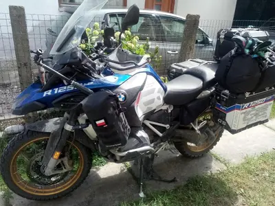a blue motorcycle parked next to a fence at Apartman Retro Una in Banja Luka