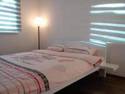 a bedroom with a bed with a lamp and a window at Apartment Kapetanovic in Bosanski Šamac