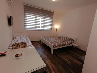 a small room with a bed and a table at Apartment Kapetanovic in Bosanski Šamac
