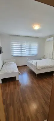 a bedroom with two beds and a wooden floor at Apartment Kapetanovic in Bosanski Šamac