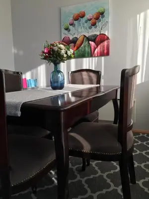 a dining room table with chairs and a vase with flowers at Stan na dan Gradiška/Bos. Gradiška in Bosanska Gradiška