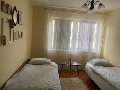 two beds in a room with a window and a table at Stan na dan Gradiška/Bos. Gradiška in Bosanska Gradiška