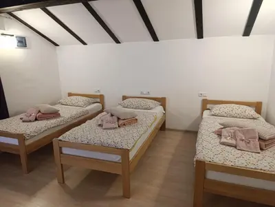 a room with three beds in a room at Naid Apartmani in Kulen Vakuf