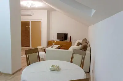 a white living room with a table and a couch at Villa Maja in Bihać