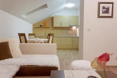 a living room with a couch and a kitchen at Villa Maja in Bihać