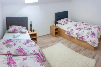 a room with two beds and a rug at Villa Maja in Bihać