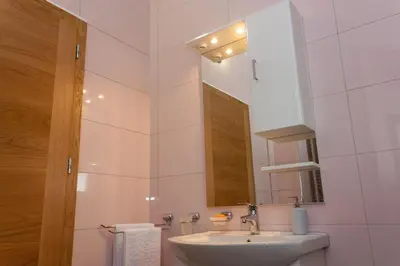 a white bathroom with a sink and a mirror at Villa Maja in Bihać