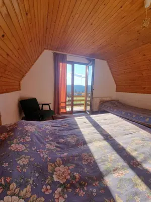 a bedroom with a large bed with a large window at Green Forest in Vlasic