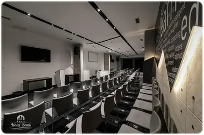 a room with rows of chairs in a classroom at Hotel Bank in Kiseljak