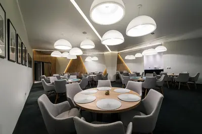 a conference room with tables and chairs and lights at Hotel Bank in Kiseljak