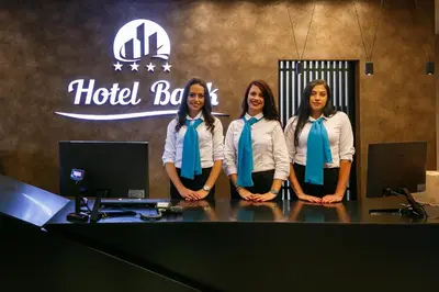 a group of three women wearing ties standing at a desk at Hotel Bank in Kiseljak