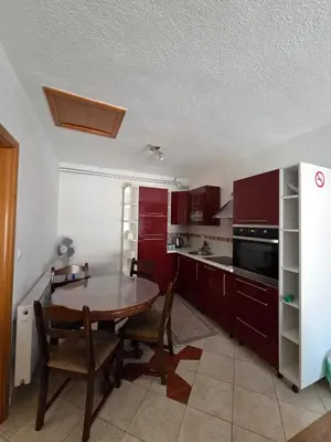 a kitchen with red cabinets and a table and chairs at Biser-Hatinac in Bihać