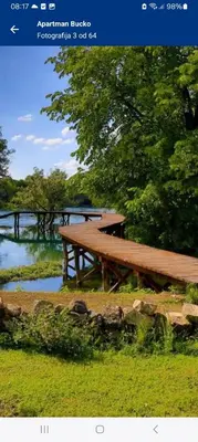 a wooden picnic table sitting next to a river at Biser-Hatinac in Bihać