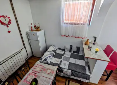 a small bedroom with a bed and a table at Apartment LAMI - Kalibunar, Travnik in Travnik