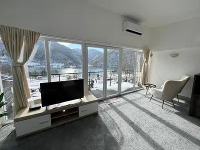 a living room with a tv and a large window at Apartment 
