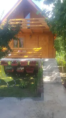a log cabin with a porch and a bench in front at Vacation home SAJRA in Kulen Vakuf