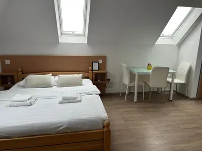 a bedroom with a bed and a table with chairs at Apartmani Waterfall / Vodopad in Jajce