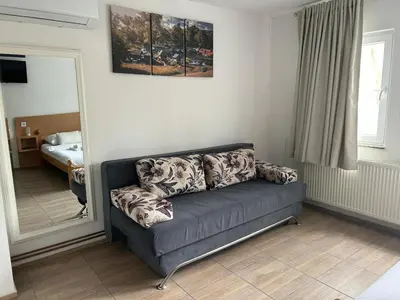 a couch in a living room with a mirror at Apartmani Waterfall / Vodopad in Jajce