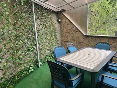 a table and chairs in front of a wall at Apartmani Waterfall / Vodopad in Jajce