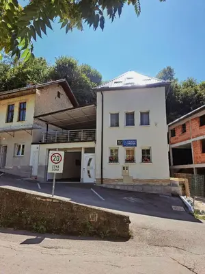 a white building with a no parking sign in front of it at Apartmani Waterfall / Vodopad in Jajce