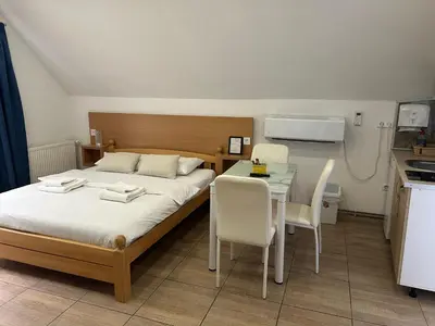 a bedroom with a bed and a table with chairs at Apartmani Waterfall / Vodopad in Jajce