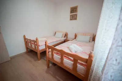two twin beds in a room with wooden floors at Apartman Lucija in Livno