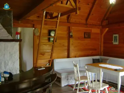 a dining room with a table and chairs and a wooden wall at Guest House VEZ Bihac in Bihać