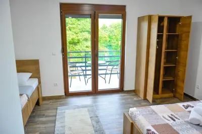 a room with two beds and a door with a balcony at Villa Sabina in Lohovo