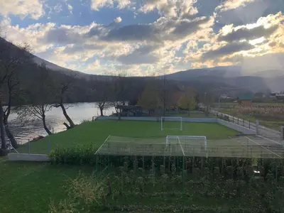 a tennis court on a field next to a lake at Villa Sabina in Lohovo