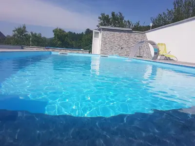 a large swimming pool with blue water at Holiday Home Emir in Račić