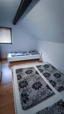 two beds in a room with black and white rugs at Holiday Home Emir in Račić