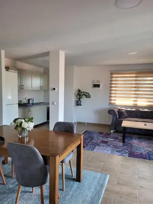 a living room with a table and a couch at Apartmani ELEGANCE Tuzla in Tuzla