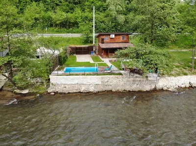 a house with a swimming pool next to a river at Paradise on the Vrbas River in Jajce