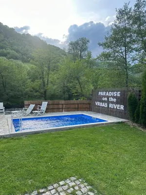 a sign that reads paradise on the washee river next to a pool at Paradise on the Vrbas River in Jajce