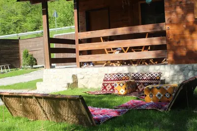 a bench sitting in the grass in front of a building at Paradise on the Vrbas River in Jajce