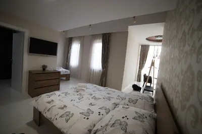 a bedroom with a bed and a dresser and a television at Hotel Urban in Bužim