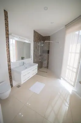 a white bathroom with a toilet and a sink at Hotel Urban in Bužim