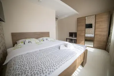 a bedroom with a large bed and a mirror at Hotel Urban in Bužim