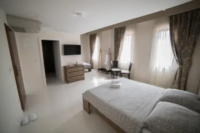 a bedroom with a bed and a desk and a television at Hotel Urban in Bužim