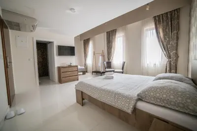 a bedroom with a large bed and a television at Hotel Urban in Bužim