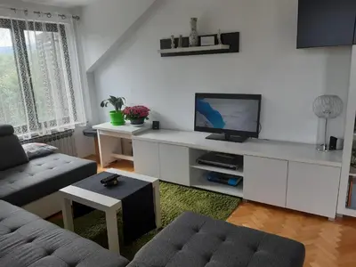 a living room with a tv on a white counter at Receptiva BL in Banja Luka