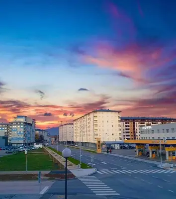 a city street with buildings and a cloudy sky at Omega in Doboj